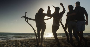 Plaj gün batımını izlemek için oturarak çiftler silüeti