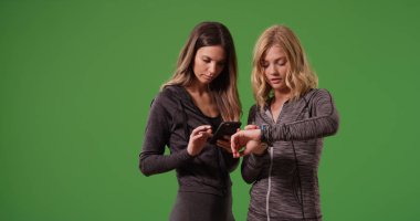 Genç çekici fitness kadınlar onların smartwatches yeşil ekranda arıyor