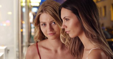 Esmer ve sarışın ciddiyet ile birlikte şehrin dış dükkanı poz