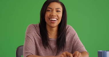 Afrikalı-Amerikalı kadın kameraya yeşil ekranda arıyor gülüyor