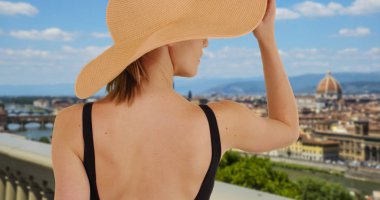 Arkadan Görünüş Floransa'da şık kadın turist trendy sunhat giyiyor