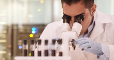 Bin yıllık İspanyol tıbbi araştırma bilim adamı laboratuarda mikroskop kullanarak