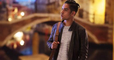 Yakışıklı Latin erkek ayakta dışarıda akşam su kanalı tarafından