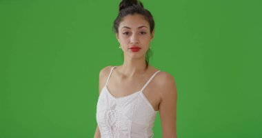 Latin bir kadın için bir portre yeşil ekran üzerinde güneş elbiseyle poz veriyor