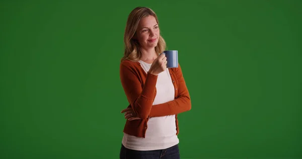 沉思的高加索妇女站在绿色屏幕上的咖啡杯 — 图库照片