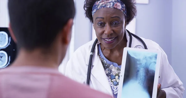 Kind Senior Medical Doctor Explaining Young Male Patient His Neck — Stock Photo, Image