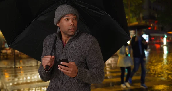 Africano Masculino Segurando Guarda Chuva Usando Telefone Celular Cidade Chuvosa — Fotografia de Stock