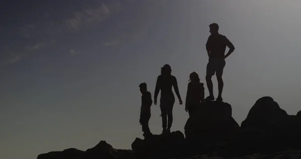 Silhouet Van Vrienden Staande Rotsen Bij Het Strand — Stockfoto