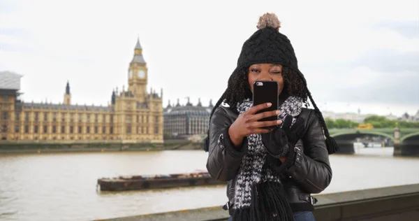 可爱的黑人妇女在伦敦旅行采取自拍与移动设备 — 图库照片