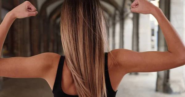 Vista Posteriore Della Donna Atletica Bicipiti Flessione Nel Corridoio Esterno — Foto Stock