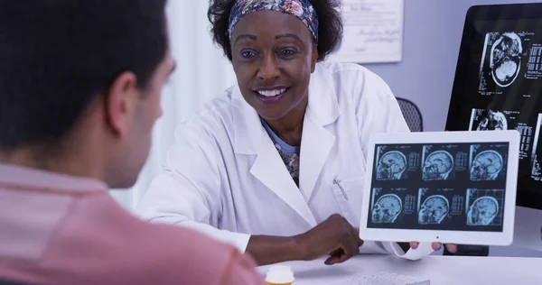 女医生向年轻的拉丁裔病人解释他的核磁共振结果的特写镜头 — 图库照片