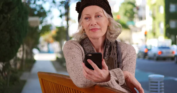 Anziani Donna Bianca Seduta Fuori Sulla Panchina Pubblica Con Smartphone — Foto Stock