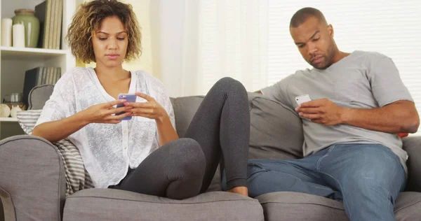 在沙发上使用智能手机的黑人夫妇 — 图库照片