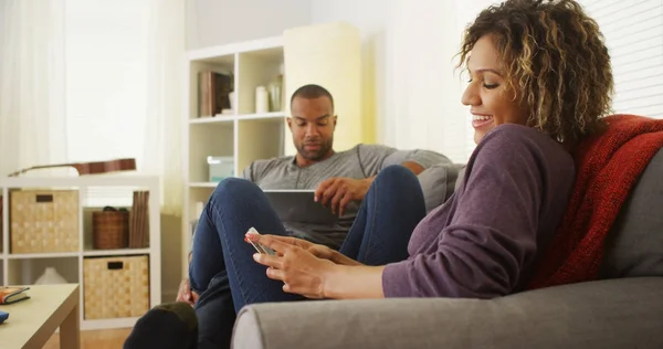 Schwarzes Paar Benutzt Elektronische Geräte Auf Dem Sofa — Stockfoto