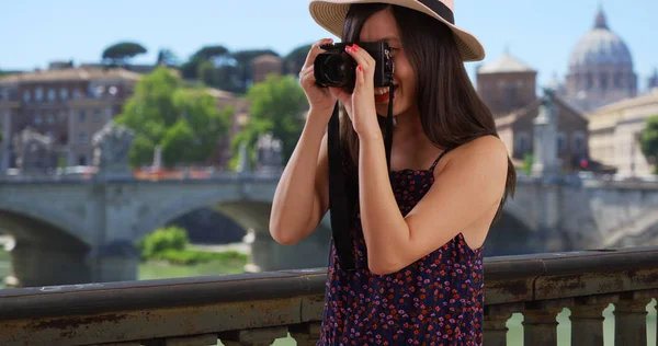 Closeup of Asian millennial photographer taking pictures by the Vatican in Rome
