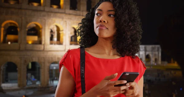 Svart Kvinna Turist Textmeddelanden Smart Telefon Utanför Colosseum Nattetid — Stockfoto