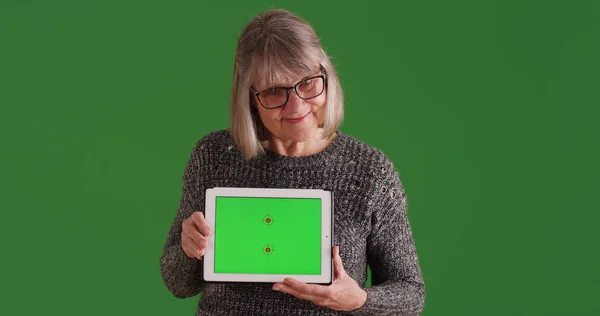 Usmívající Žena Ukazuje Tablet Fabion Stojící Zelené Obrazovce — Stock fotografie