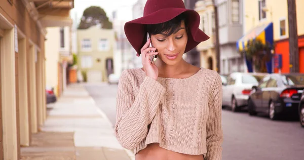 サンフランシスコのスマート電話で話しているフロッピー帽子に幸せな笑みを浮かべて黒女 — ストック写真