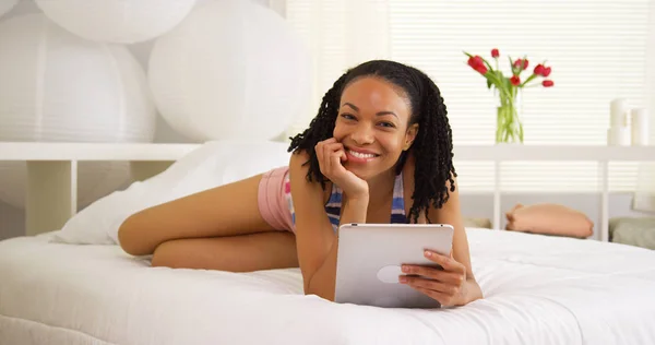Schwarze Frau Lächelt Mit Tablette Auf Dem Bett — Stockfoto