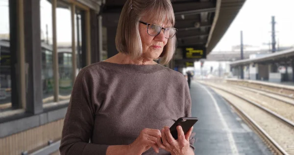 Seniorin Mit Telefonempfang Über Neuigkeiten Bahnhof — Stockfoto