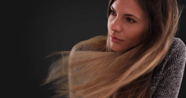 灰色の背景に風に吹かれて長い茶色の髪を持つ美しい女性 — ストック写真