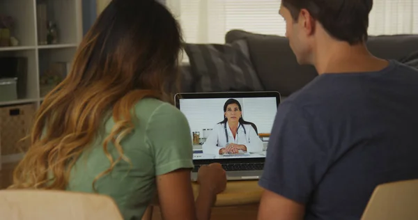 种族间的夫妇在笔记本电脑上与医生交谈 — 图库照片