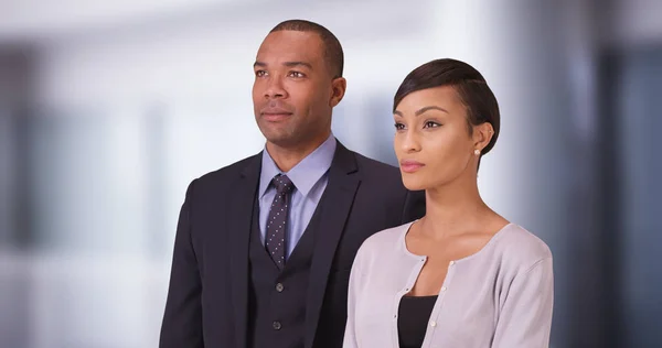 Black business couple posing for a portrait in their office