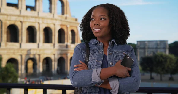 Casual portrait of black woman with radiant smile Roman coliseum in background