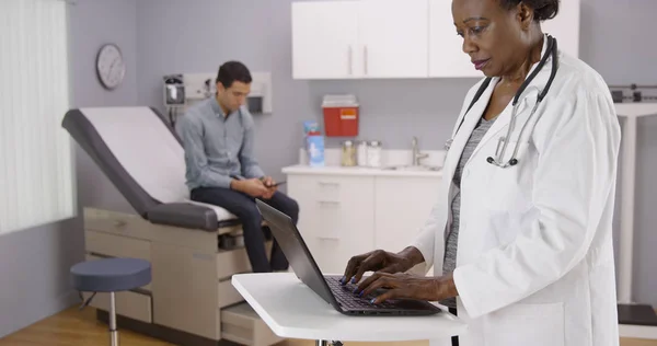 Mid Aged Female African Doctor Recording Patient Health Condition Computer — Stock Photo, Image