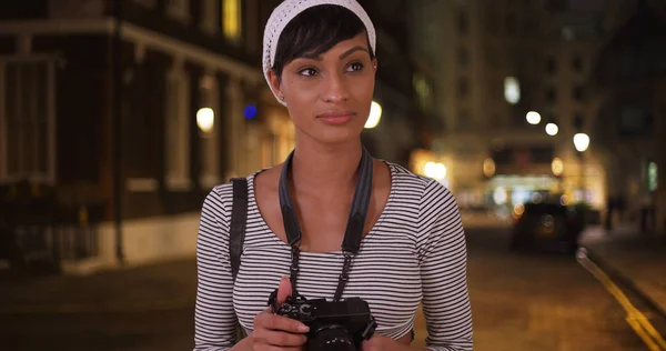 黑人妇女看照片 而在城市拍摄在晚上 — 图库照片