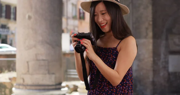 Closeup of Asian millennial photographer taking pictures in Rome Italy