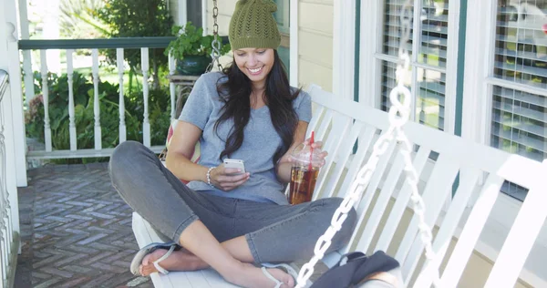 Gemengd Ras Vrouw Texting Het Drinken Van Thee Veranda — Stockfoto