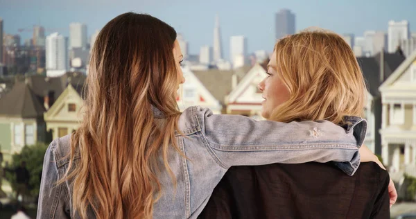 Pair of friendly women holding each other in San Francisco residential area