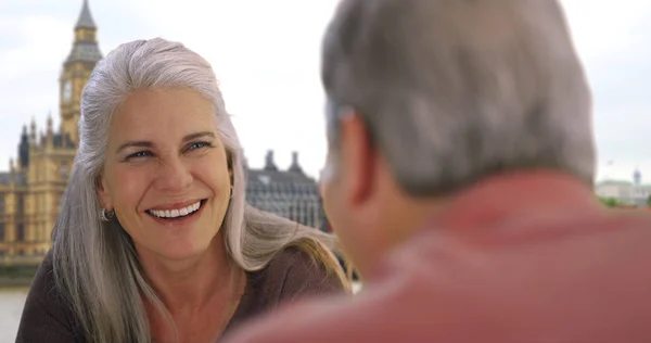 Older white couple have pleasant conversation near Big Ben in London