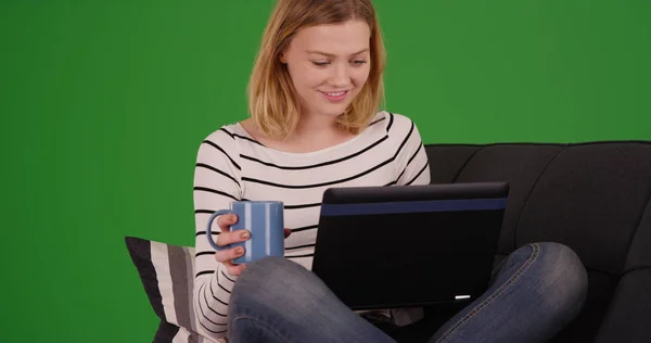 Блондинка Кавою Сидить Дивані Переглядаючи Веб Ноутбуці Зеленому Екрані — стокове фото