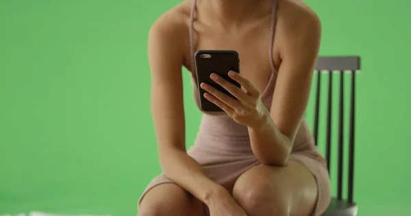 Черная Девушка Ночной Рубашке Смотрит Через Свой Смартфон Зеленом Экране — стоковое фото