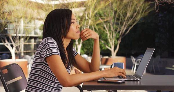 Pensoso Nero Femmina Seduta Tavola All Aperto Digitando Sul Computer — Foto Stock