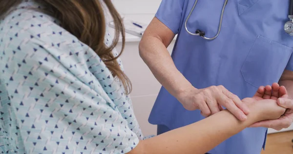 Медична Медсестра Перевіряє Пульс Молодого Пацієнта Приміщенні Медичної Клініки — стокове фото