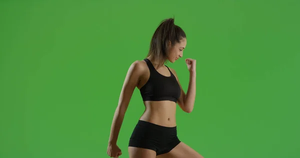 A Hispanic girl does a power pose on green screen