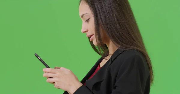 一名西班牙裔上班族在她的手机上的绿屏短信 — 图库照片