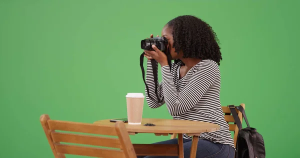黑色女摄影师在绿色屏幕上与 Dslr 在咖啡馆合影 — 图库照片