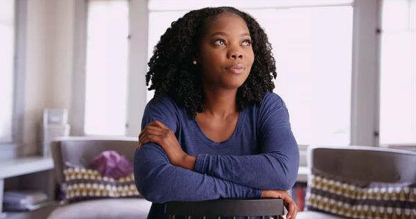 Retrato Sorrindo Mulher Negra Pensativo Sentado Para Trás Cadeira Casa — Fotografia de Stock