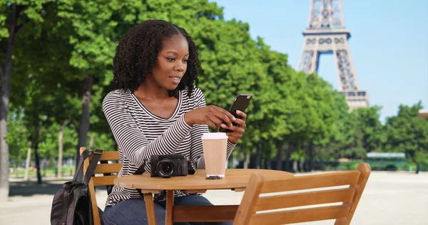 Leende Svart Kvinna Sitter Vid Bordet Sms Mobiltelefon Nära Eiffeltornet — Stockfoto