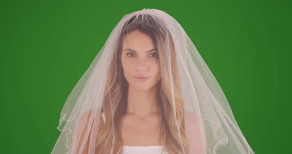 美丽的新娘在面纱看着在绿色屏幕上的相机 — 图库照片