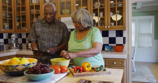 Retired black couple cooking in the kitchen