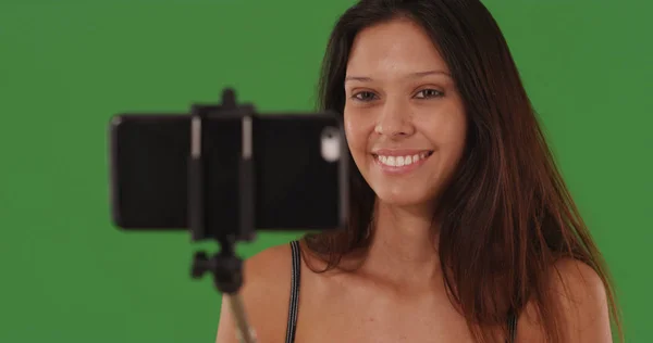 可爱的女性的肖像与智能手机在自拍棒在绿色屏幕上 — 图库照片