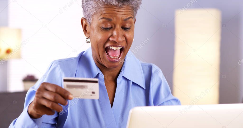 Happy Mature African woman buying things online