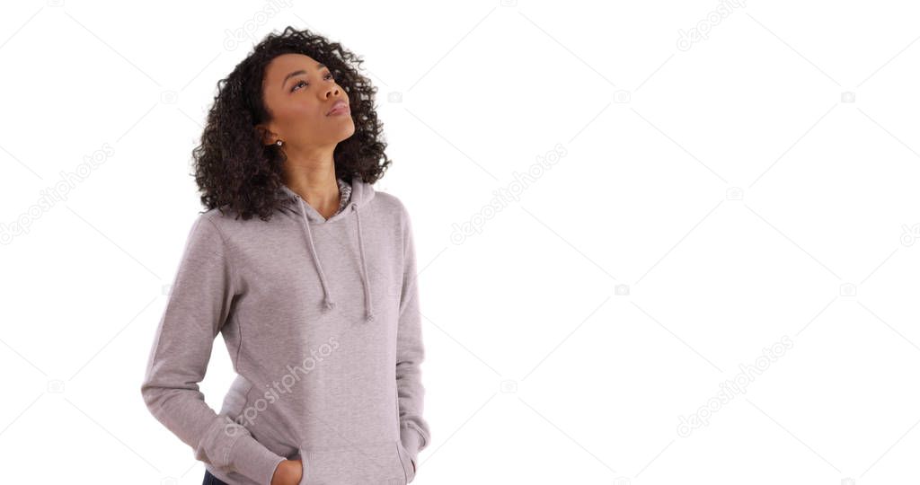 Curious African-American woman looking up at something on white background