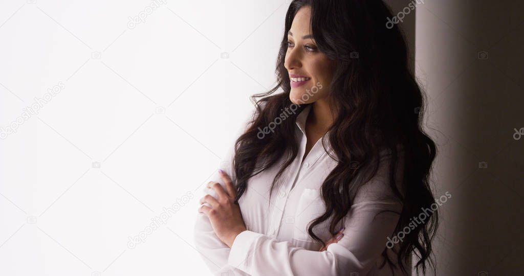 Cute Mexican businesswoman laughing by window