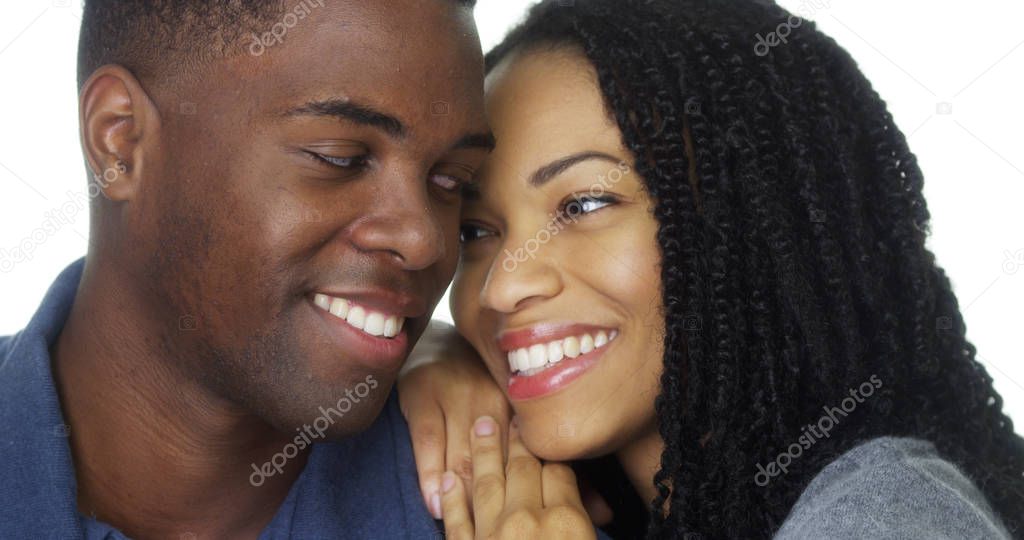 Young black woman leaning against boyfriend on white background